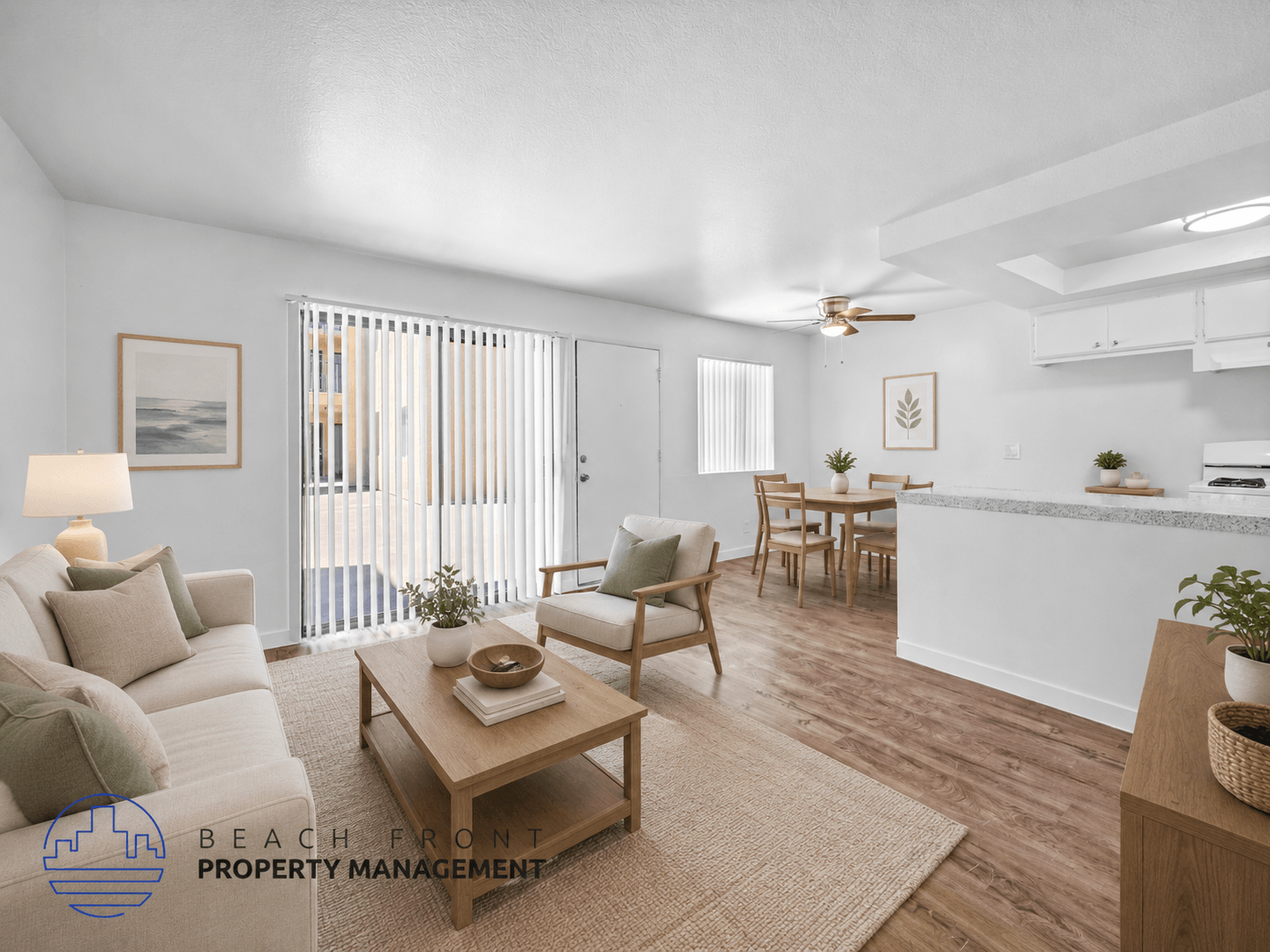 A living room with a white couch, a coffee table, and a dining table with chairs.